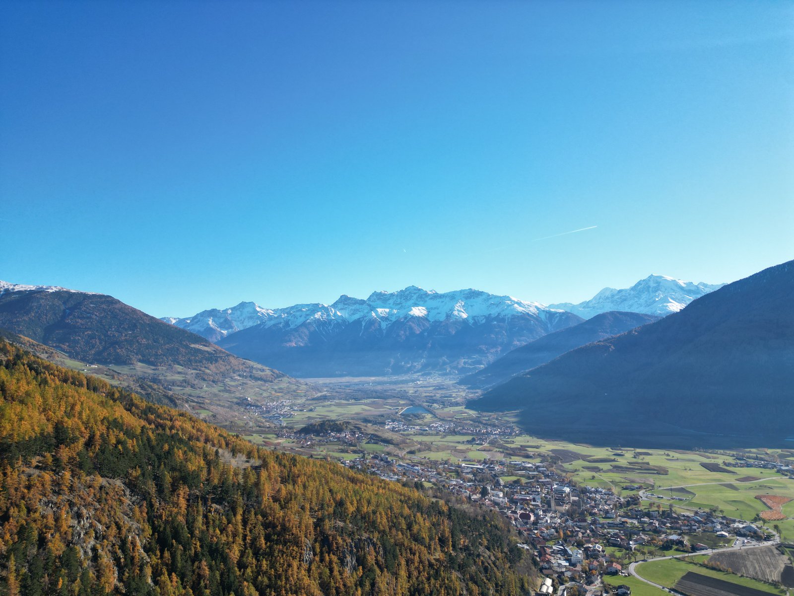 Lana South Tyrol valley aerial view with autumn larches and Alps, Etschtal