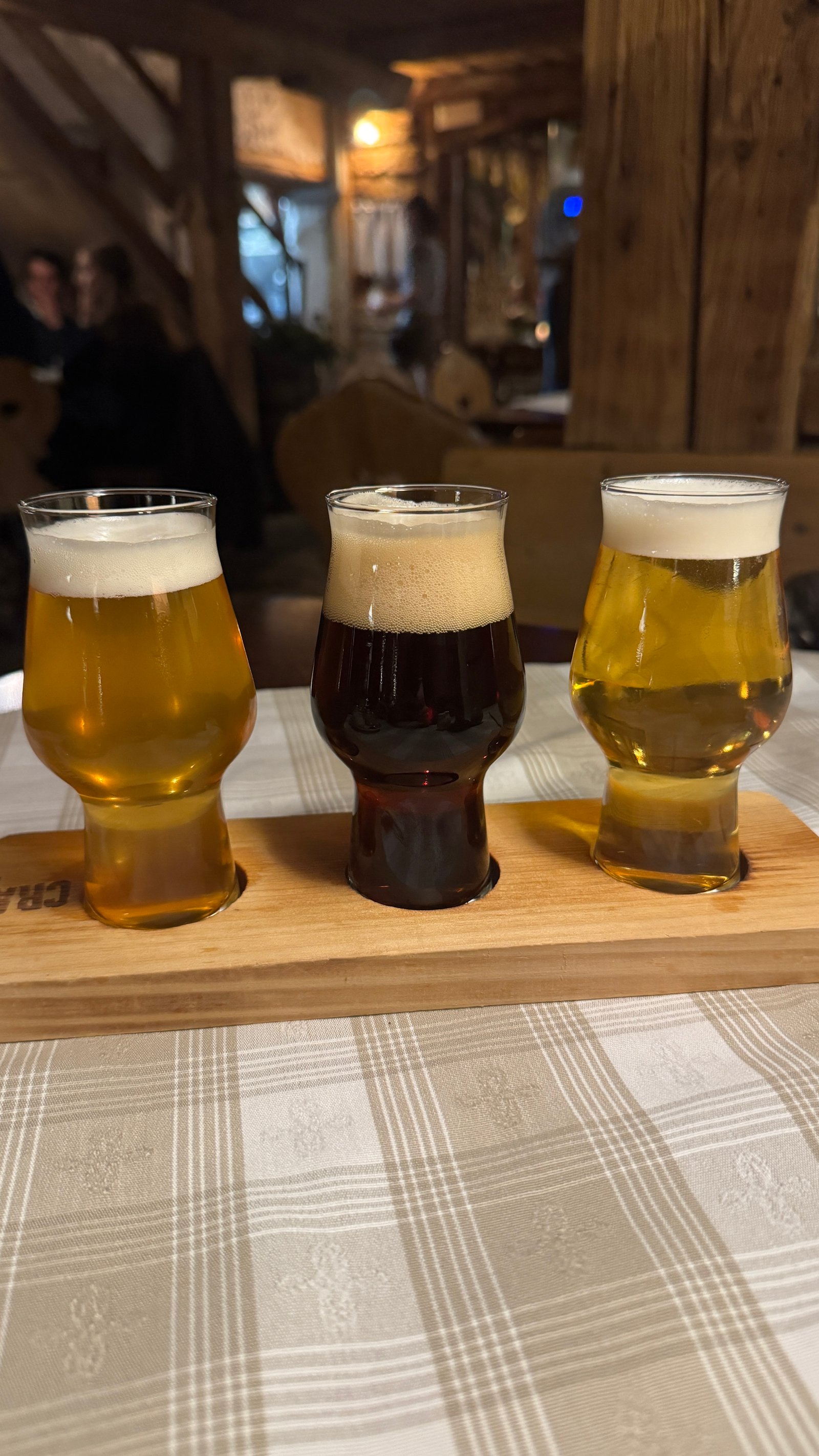 Pfefferlechner Lana beer tasting flight — three glasses on wooden board