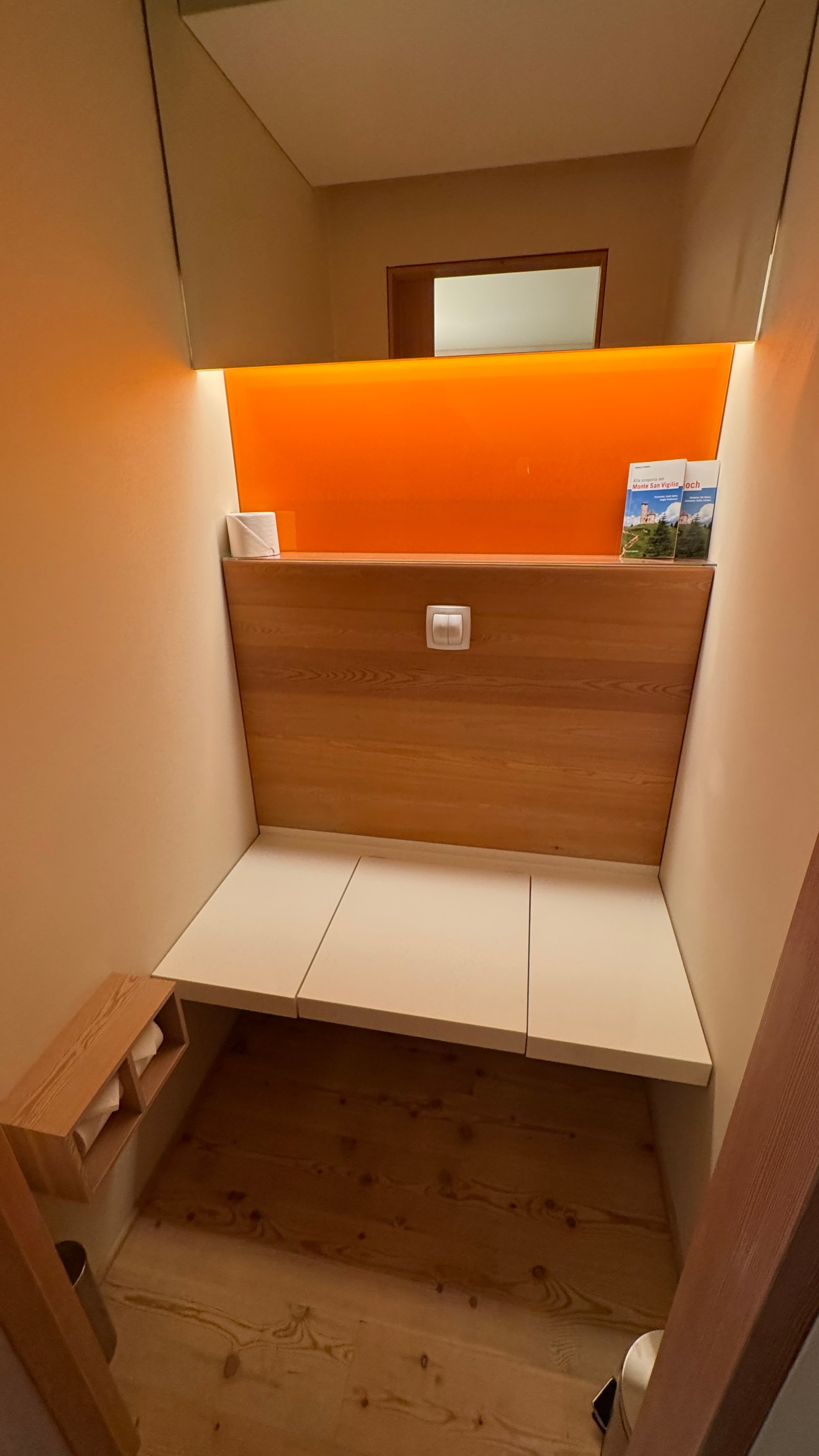 Vigilius Mountain Resort toilet room with orange backlit panel and wood paneling
